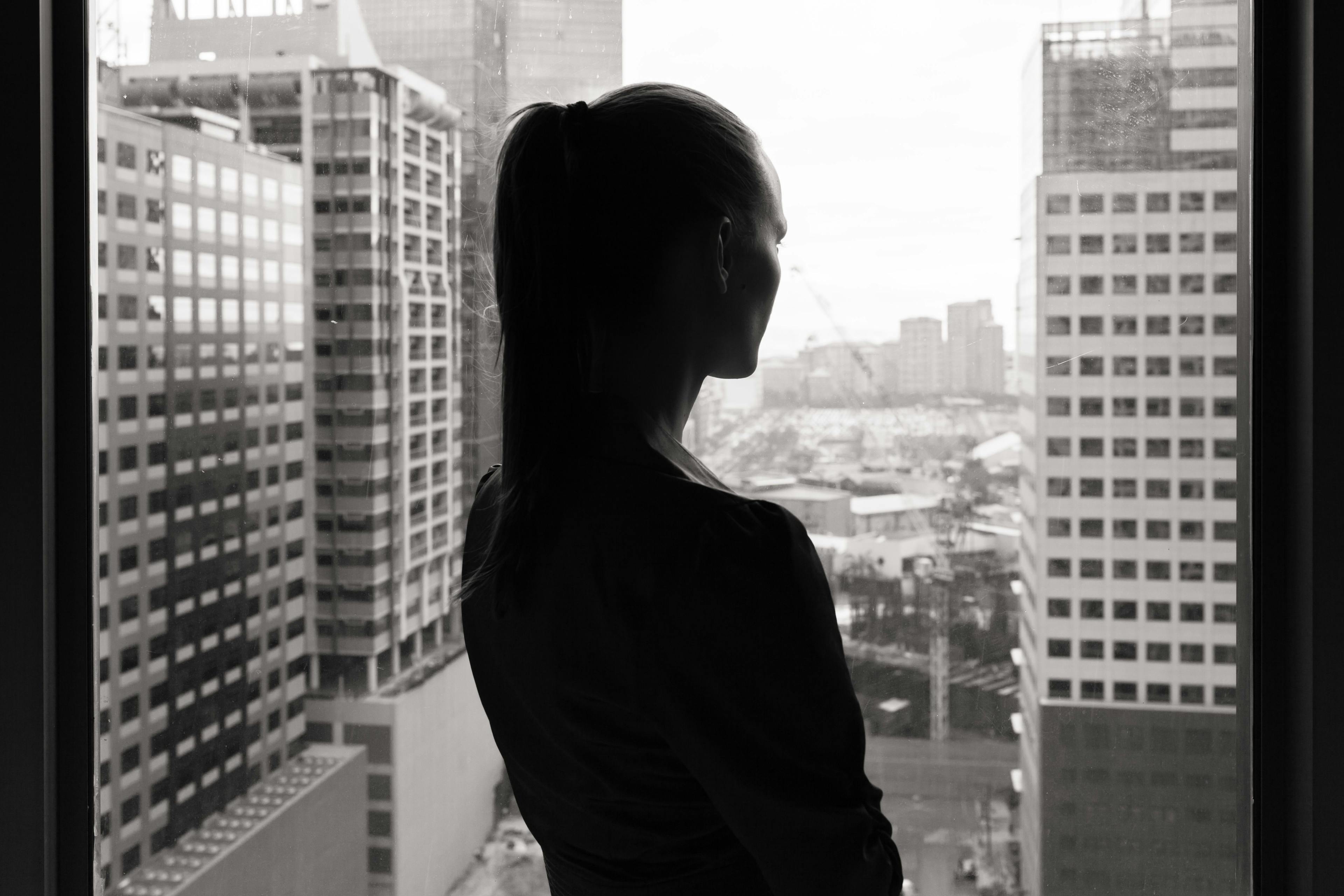 Business woman looks out on city skyline